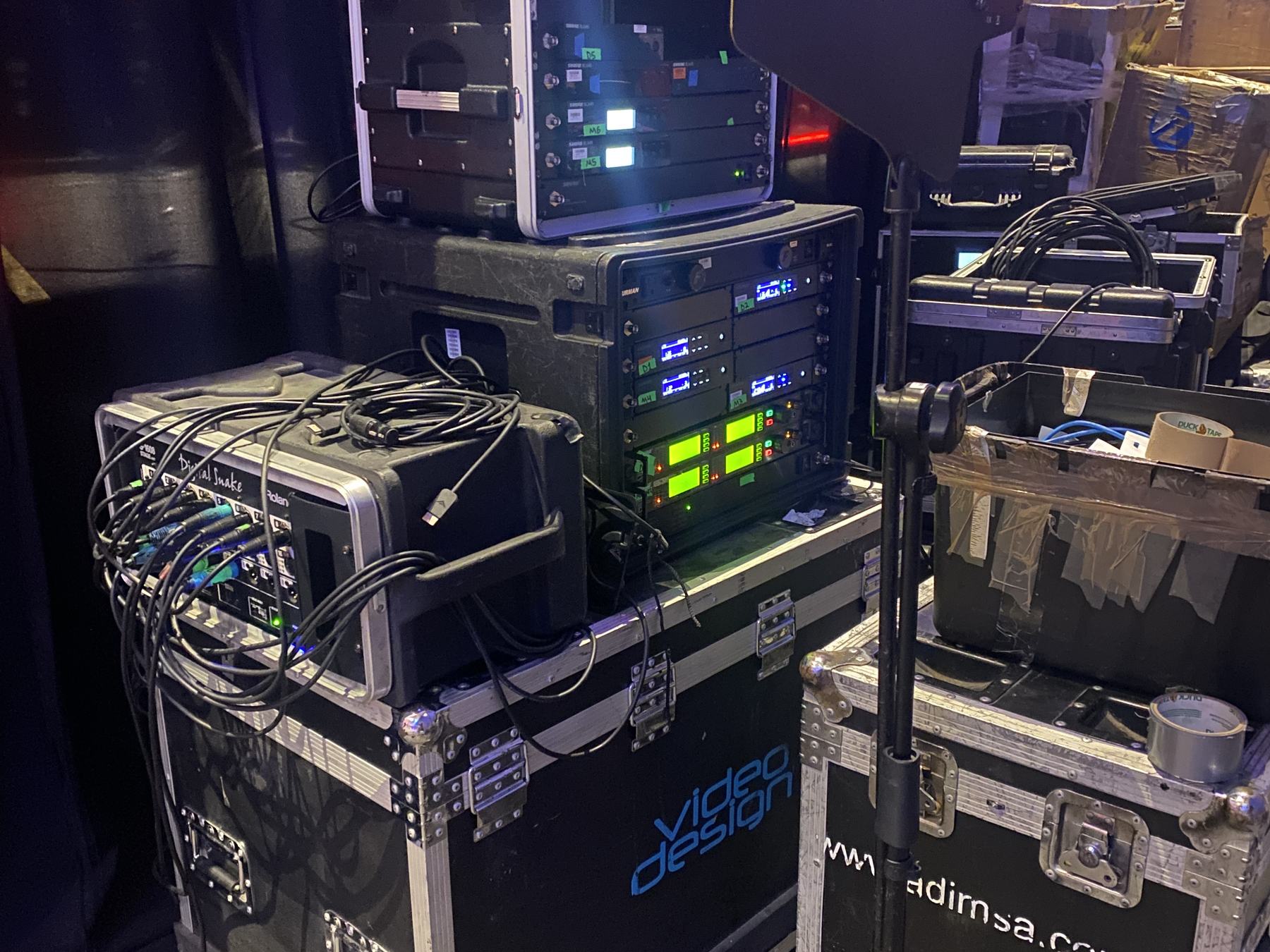 Racks de equipo de VideoDesign en backstage durante un evento, con receptores y procesamiento encendidos
